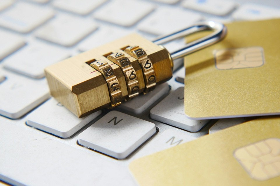Un cadenas à code posé sur le clavier d'un ordinateur.